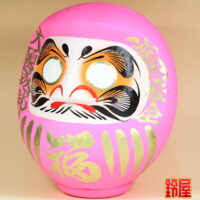 良縁祈願の縁起物であるピンクの高崎だるま：左斜め前画像
